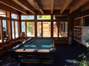 a pool table in the middle of a room withwindows at Hotel Meielisalp in Leissigen