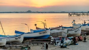 a group of boats parked on the beach near the water at GENIKO Apartments in Pomorie
