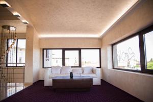 ein Wohnzimmer mit weißem Sofa und Fenstern in der Unterkunft Le Mer in Afumaţi