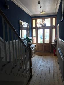 um corredor com paredes azuis e uma escada com uma porta em The Sandpiper em Barmouth