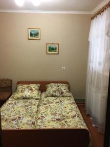 un letto in una camera da letto con due immagini sul muro di Sadyba u Mykhaila a Kosonʼ