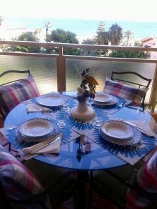 a blue table with plates and napkins on a balcony at Apartamento PuigVal in El Puig