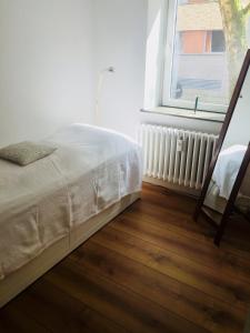 Schlafzimmer mit einem Bett und einem Fenster in der Unterkunft Apartment am Blücher in Kiel