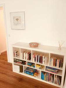 ein weißes Bücherregal gefüllt mit Büchern in einem Raum in der Unterkunft Apartment am Blücher in Kiel