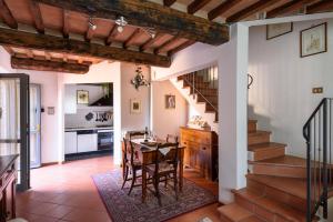 uma cozinha e sala de jantar com uma mesa e escadas em Tuscany Balcony: Crete Senesi em Casetta