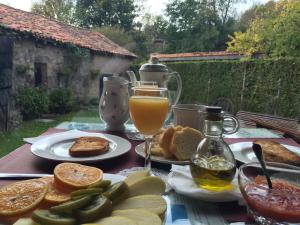 una mesa con platos de comida y un vaso de zumo de naranja en Posada Rural Fontibre, en Fontibre
