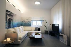 uma sala de estar com um sofá branco e uma televisão em Little Small Villa In Psychiko, Athens em Atenas