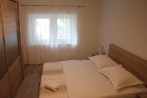 - une chambre avec un grand lit et une fenêtre dans l'établissement Apartman Tafra, à Omiš