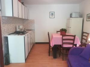 a small kitchen with a table and a kitchen with a table and a tableablish at Apartman Legac in Starigrad