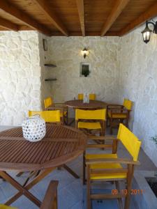 a dining room with wooden tables and yellow chairs at Paralia in Flogita