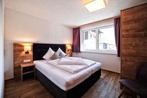 a bedroom with a large bed with a window at Amaris Apartments in Ischgl