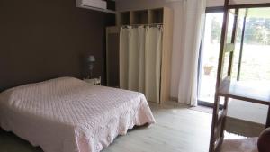 萊托的住宿－Safranière des Sorgues，卧室配有白色的床和滑动玻璃门