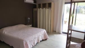 a bedroom with a white bed and a sliding glass door at Safranière des Sorgues in Le Thor