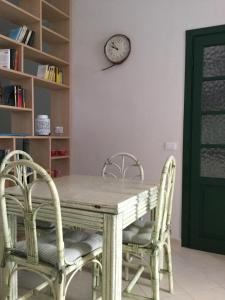 una mesa con dos sillas y un reloj en la pared en Freja, en SantʼAntìoco