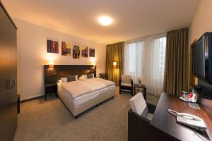 ein Hotelzimmer mit einem Bett und einem TV in der Unterkunft Hotel Cristobal in Hamburg