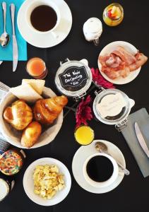 una mesa con platos de comida y tazas de café en Logis Hôtel Le Glacier, en Orange