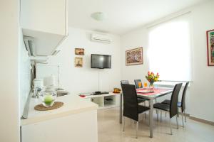 Apartment Bose في سبليت: مطبخ وغرفة طعام مع طاولة وكراسي