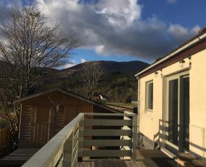 a house with a wooden ramp next to a building at Cosy Cottage in Glencoe