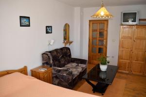 a bedroom with a couch and a chair and a table at Стаи за гости "КАТИ" Guest rooms "KATI" in Balchik