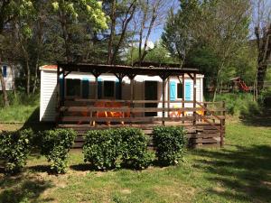 a small cabin with a porch in a yard at Camping Les Gorges de l'Hérault in Sumène