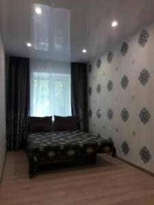 um quarto com uma cama num quarto com uma janela em Apartment On Rabochaya 81 em Dnipro