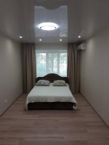 um quarto com uma cama e uma grande janela em Apartment On Rabochaya 81 em Dnipro