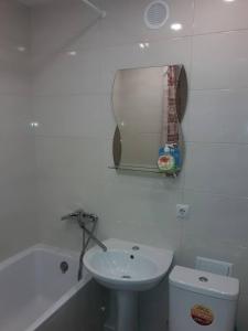 La salle de bains blanche est pourvue d'un lavabo et de toilettes. dans l'établissement Apartment On Rabochaya 81, à Dnipro