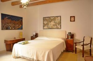 1 dormitorio con 1 cama blanca y 1 silla en Guest House Sa Succargia en Baunei