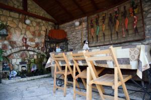 a table and chairs in front of a stone wall at Стаи за гости "КАТИ" Guest rooms "KATI" in Balchik