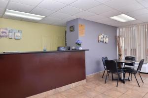 a bar in a waiting room with a table and chairs at Americas Best Value Inn West Monroe in West Monroe