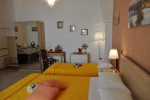 a hotel room with two beds with yellow sheets at 7 Contrade in Taranto