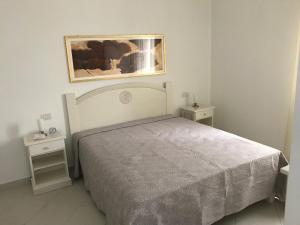 een slaapkamer met een bed en een schilderij aan de muur bij Casa Gigi in Olbia