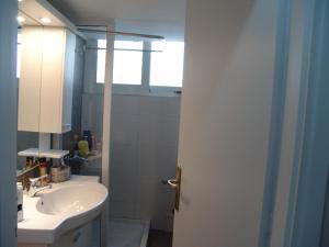 Grace Apartments في لوتراكي: حمام مع حوض ومرآة
