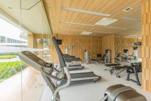 a gym with tread machines and a glass wall at Veranda Residence Pattaya by Boom in Na Jomtien