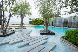 a swimming pool with trees in the middle of it at Veranda Residence Pattaya by Boom in Na Jomtien