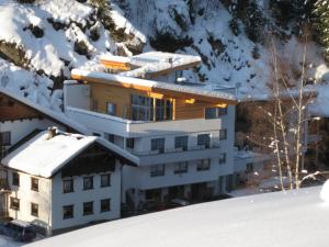 un edificio en la nieve con árboles nevados en Apart Kathrin, en Kappl