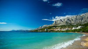 a view of a beach with a mountain in the background at Apartments Kurtic in Makarska
