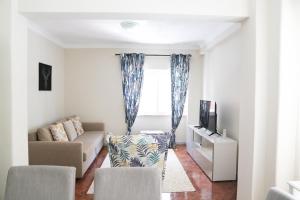 un soggiorno con divano e TV di Karioca Management a Paço de Arcos