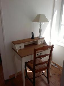 a desk with a lamp and a chair in a room at Chez Clémentine in Montolieu