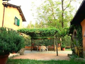 a patio with a table and chairs under a pergola at Bed and Breakfast Monticelli in Capranica