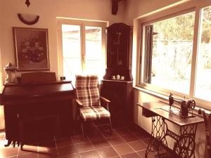 CapranicaにあるBed and Breakfast Monticelliのピアノと椅子、窓が備わる客室です。