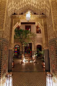 a lobby with a tree in the middle of a building at Riad Alya in Fès