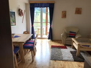 ein Wohnzimmer mit einem Tisch, Stühlen und einem Sofa in der Unterkunft Apartman Razula in Velké Karlovice