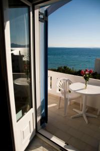 a balcony with a table and a view of the ocean at Sunrise Studios in Megalochori