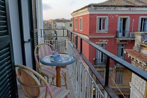 a table and chairs on a balcony with a coffee cup at Puppet rooms in Corfu