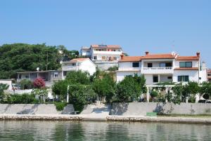 a group of buildings next to a body of water at Kampor Apartments in Kampor