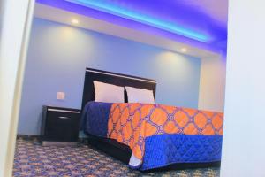 a bedroom with a bed with an orange and blue comforter at Arlington Motel in Long Beach