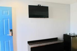 a living room with a flat screen tv on a wall at Arlington Motel in Long Beach
