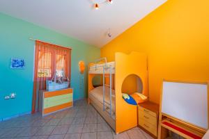 1 dormitorio con litera y pared amarilla en Ioannis House Sea View en Lourdhata