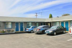 three cars parked in a parking lot in front of a building at Arlington Motel in Long Beach